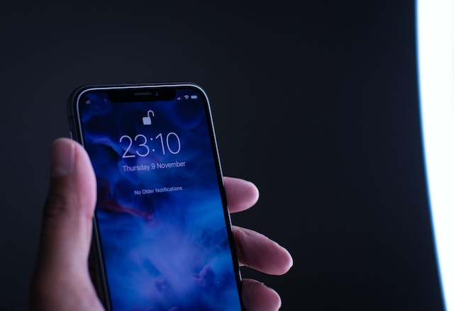 شخص يستخدم ميزة إلغاء القفل بالوجه لإلغاء قفل جهاز iPhone الخاص به.