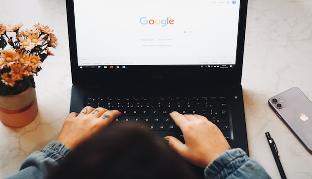شخص يستخدم محرك بحث شهير على جهاز الكمبيوتر المحمول الخاص به للبحث عن إضافة Google Chrome.