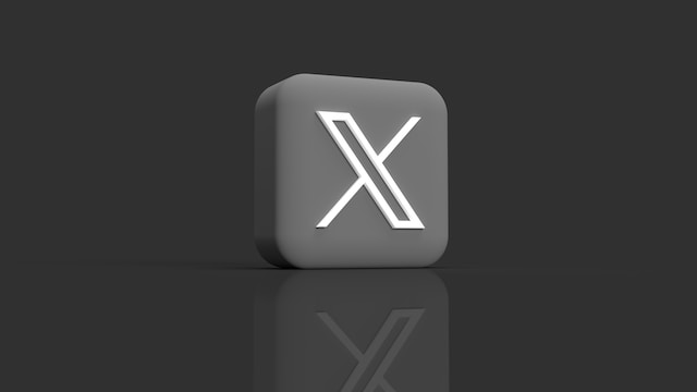 صورة 3D لمكعب رمادي على خلفية داكنة مع شعار X الجديد مطبوع عليه.