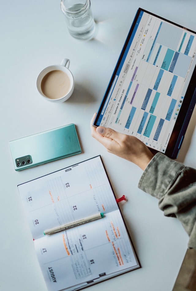 Eine Person verwendet eine Kalender-App, um ihren Zeitplan für Inhalte für X zu planen.