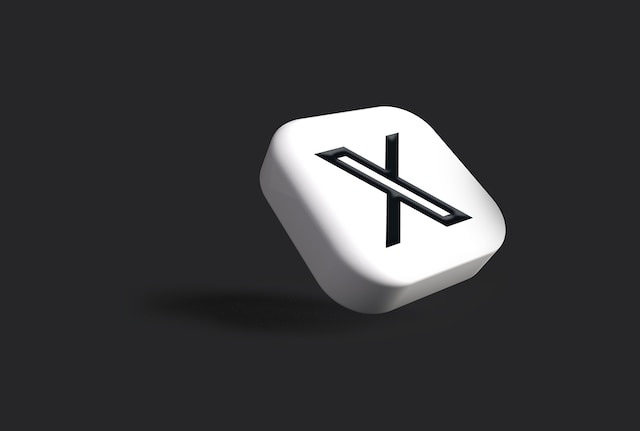 Eine 3D-Illustration eines weißen, schrägen Knopfes mit dem X-Logo in Schwarz. 