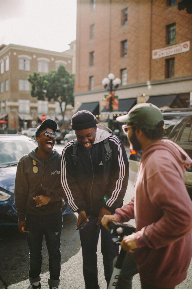 Eine Gruppe von Menschen steht auf einer Straße und lacht.