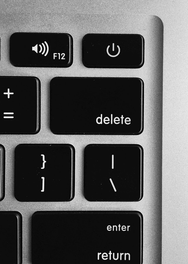 Die Löschtaste auf der Tastatur eines grauen MacBook.