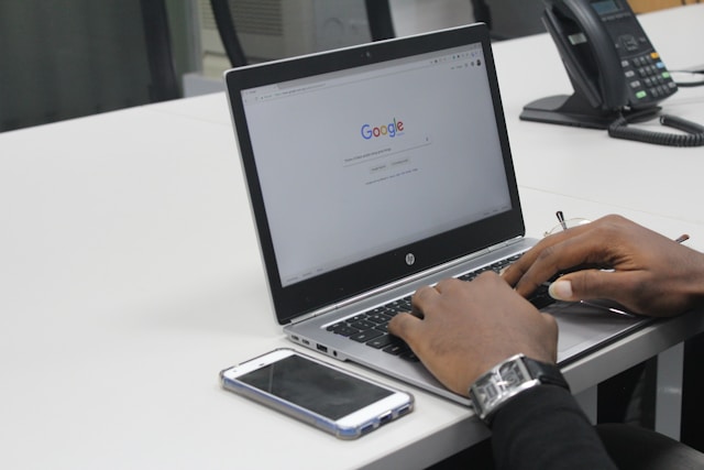 Eine Person gibt mit ihrem HP-Laptop eine Suchanfrage bei Google Search ein.