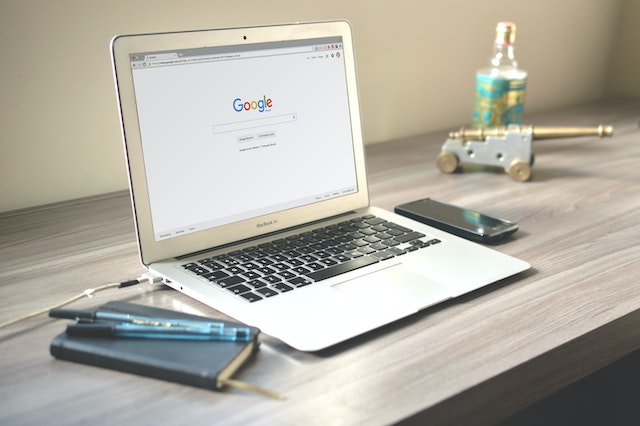 Imagen de un portátil sobre una mesa de trabajo con una nueva pestaña de Chrome abierta en el escritorio.