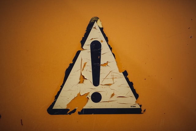 Una foto de una señal de precaución oxidada.