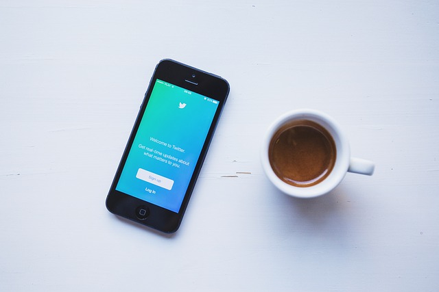 Imagen de un smartphone junto a una taza que muestra la página de creación de cuentas de Twitter.