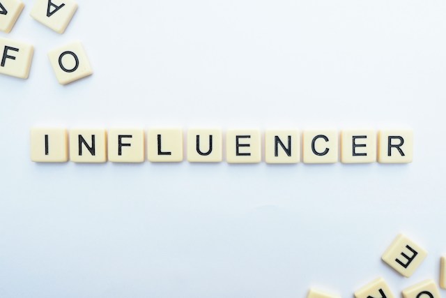 Letras mayúsculas blancas dispuestas para deletrear la palabra "influencer".