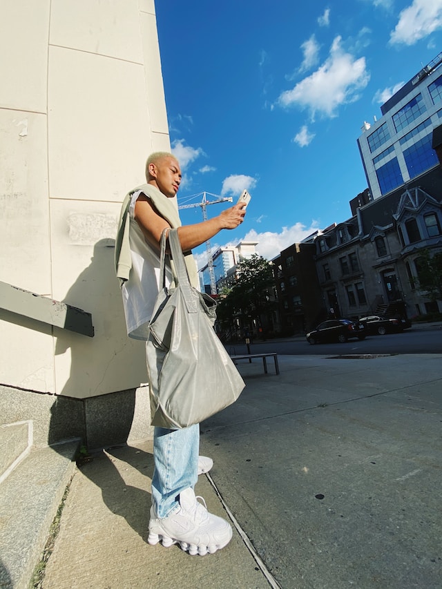 Una persona utilizando su teléfono mientras está de pie al aire libre.