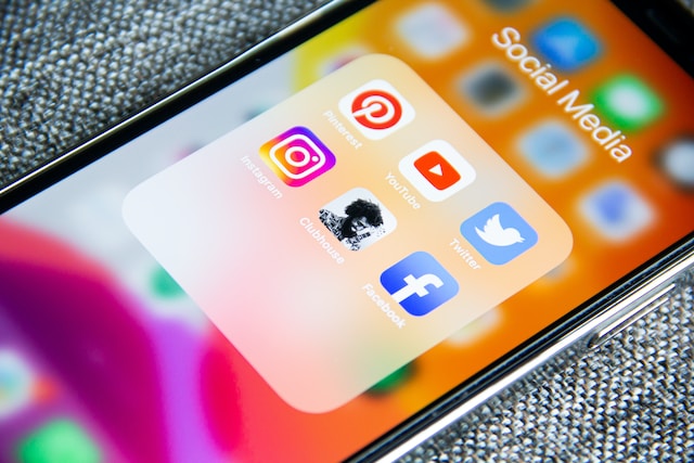 Photo d'un écran d'iPhone affichant six applications de médias sociaux, dont Twitter, dans un dossier d'applications.
