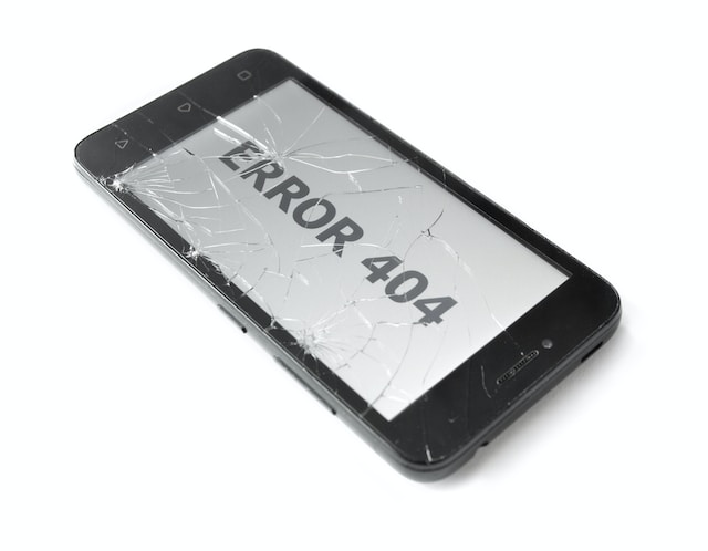 Une photo d'un écran de téléphone fissuré affichant le message "ERROR 404".