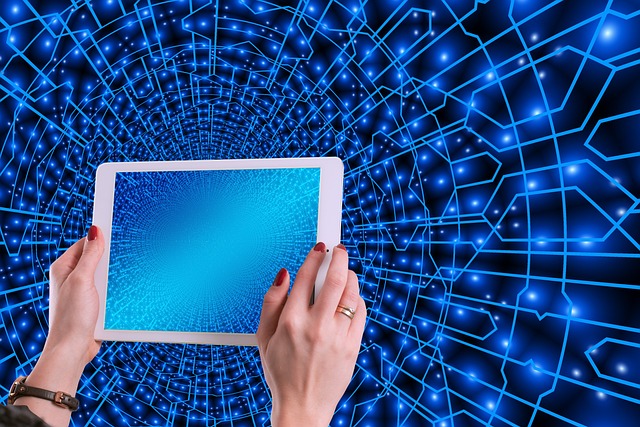 Gambar seseorang dengan tablet layar biru dan latar belakang yang menunjukkan titik-titik cahaya yang merepresentasikan interkonektivitas. 

