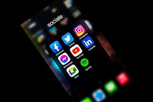 Layar iPhone yang menampilkan folder aplikasi media sosial.