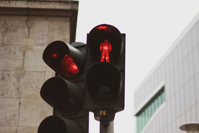 Lampu pengatur lalu lintas yang menampilkan figur lampu merah seseorang.
