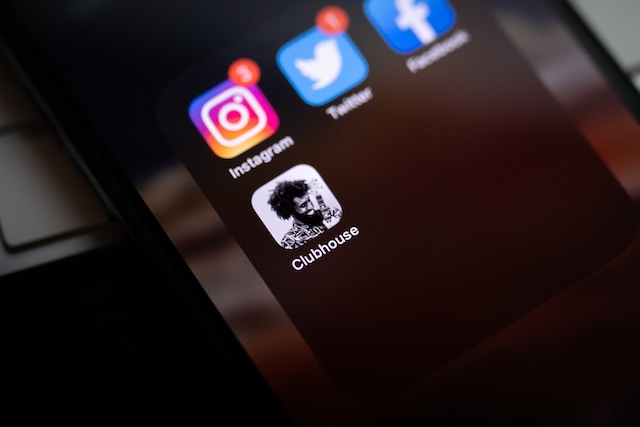 Una fotografia di un telefono nero che mostra le icone di diverse applicazioni, tra cui quella di Twitter.