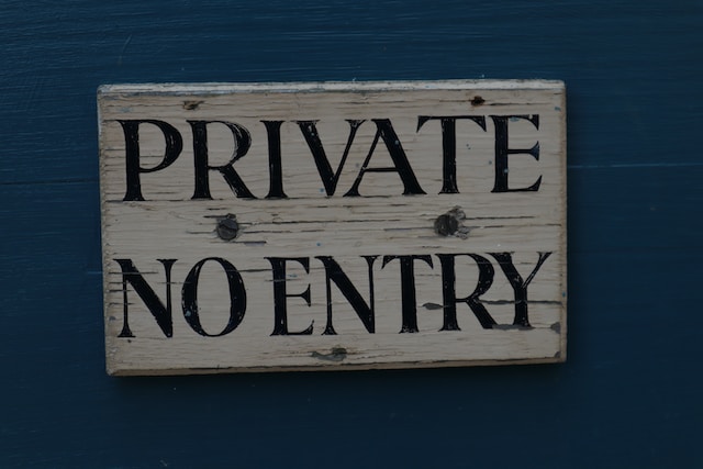 Una fotografia di un vecchio cartello di legno con la scritta "PRIVATE NO ENTRY".