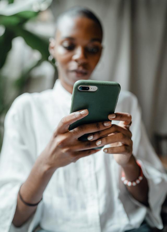 Una donna digita sul suo smartphone un nuovo nome utente per l'app X.