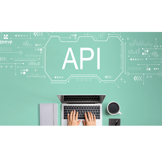  ノートパソコン、本、マグカップ、ペンと日記が、グリーンのマットに白で「API」の文字。