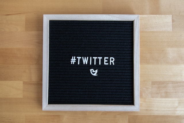 Een afbeelding van het woord '#Twitter' en het vogellogo op een schoolbord.
