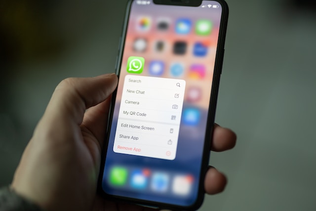 Het snelmenu van Whatsapp is geopend op een zwarte iPhone.
