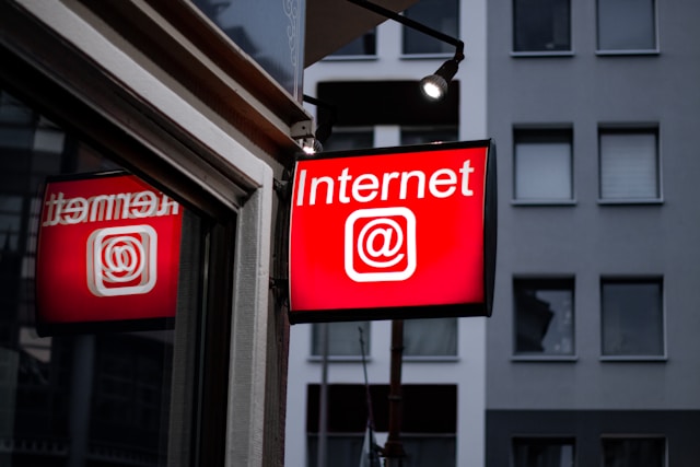 Een rood LED-bord met het woord "Internet" en het at-bord symbool in het wit.