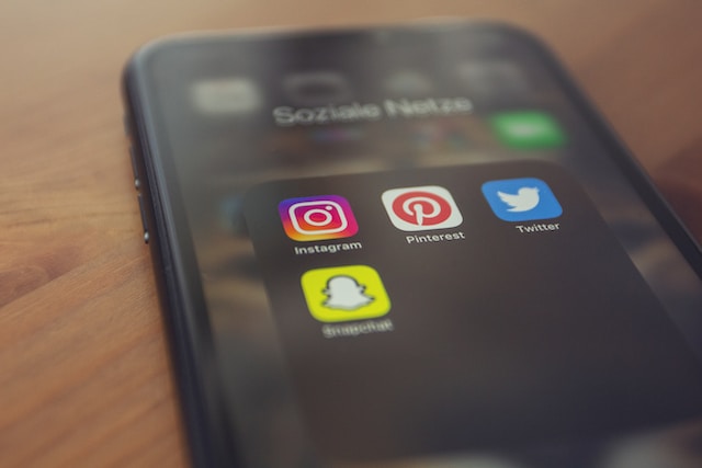 Uma fotografia de um telemóvel com a pasta de aplicações de redes sociais no ecrã.