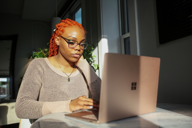 Uma mulher está a trabalhar no seu computador portátil.