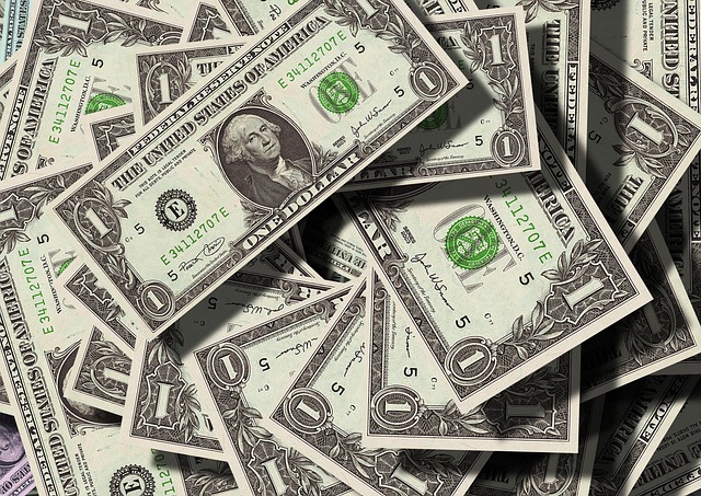 Uma pilha desordenada de várias notas de um dólar dos Estados Unidos.
