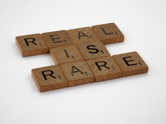 Vários blocos de madeira castanha com o texto "Real Is Rare".