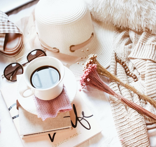 Adding a feminine touch with a cup of coffee, hat, books, sweater and sandal with the beige theme.