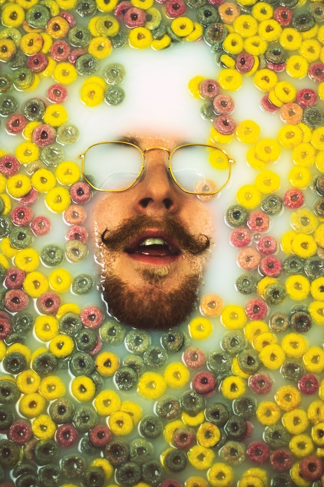 A face emerges from a milk and fruit loops bath.