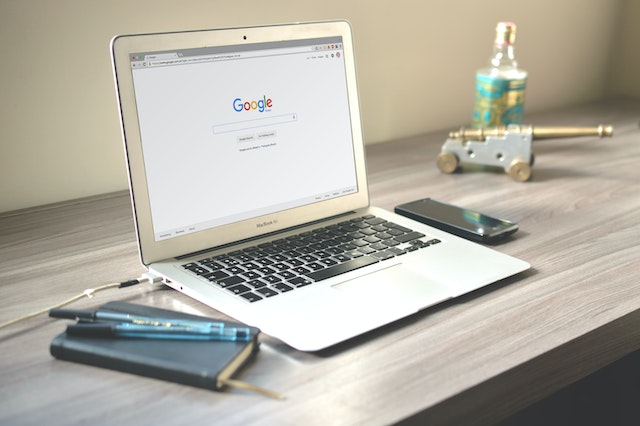 An image of a laptop on a work desk with a new Chrome tab opened on the desktop.