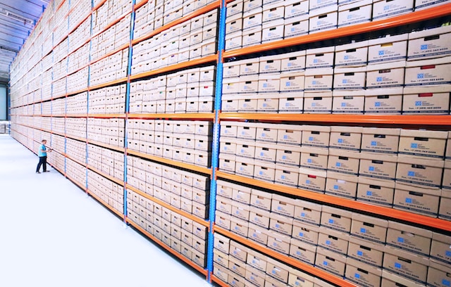A picture of large rows of paper archives stacked from the floor.