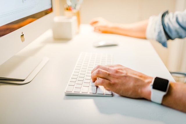 A person is checking their Twitter profile on an iMac for signs of bot-like activity from their followers.