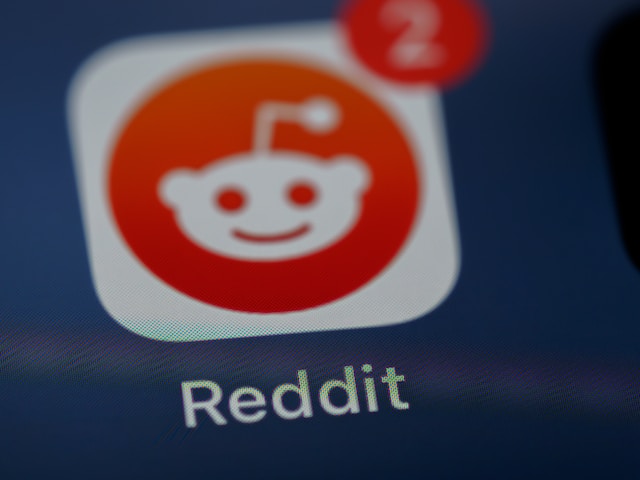 A closeup photo of the Reddit app tile on an iPhone screen.