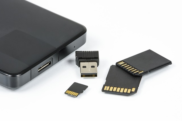 A photograph of a hard drive, USB drive and memory cards spread on a white background.