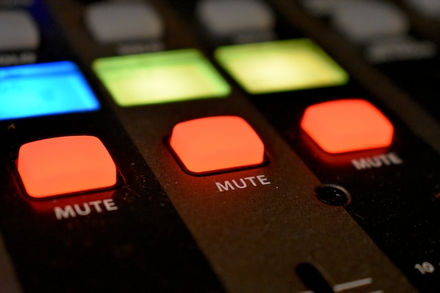 A picture highlighting three red buttons on a mixer labeled “MUTE.”