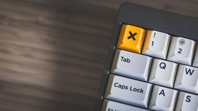 A closeup photo of a keyboard with a yellow “X” button.