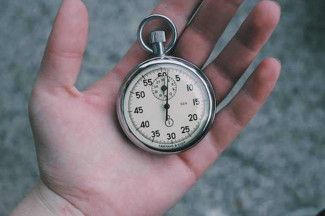 Een foto van een persoon met een zakhorloge in zijn handpalm.