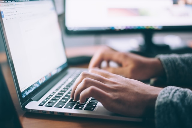 A photo of a person typing on a MacBook Pro.