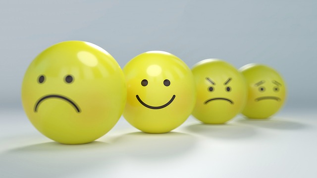 Four yellow emoji balls portraying emotions like sadness, happiness, anger, and unhappiness.