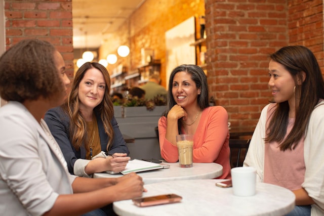 A group of four women meet in a restaurant.