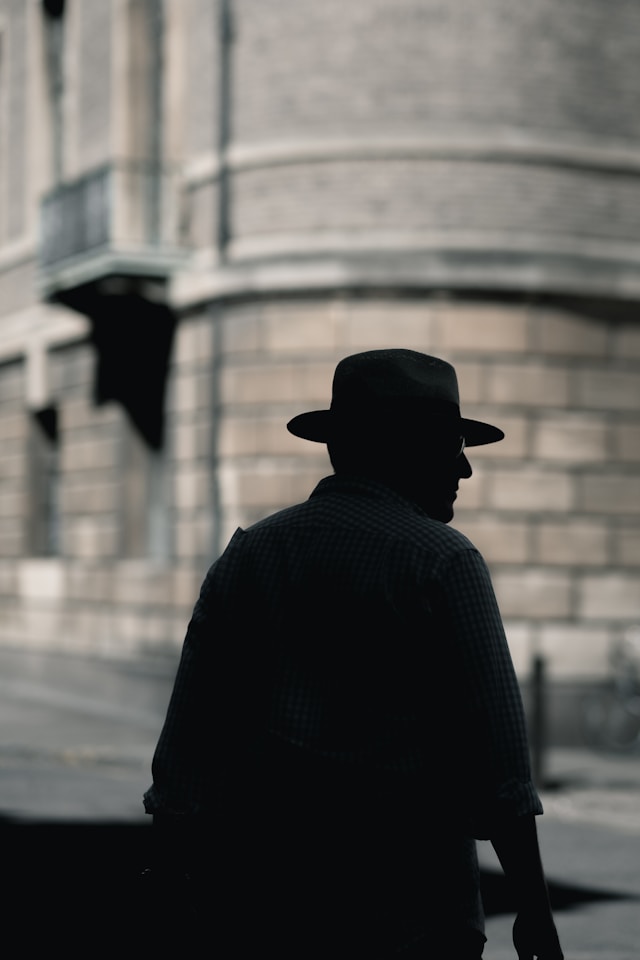 The silhouette of a person with a hat.