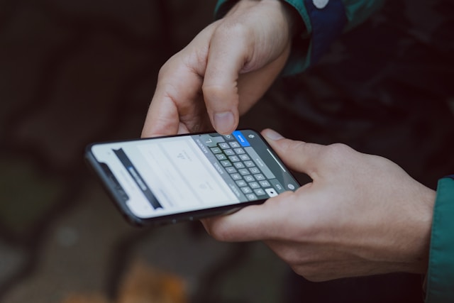 A person holds a black iPhone.