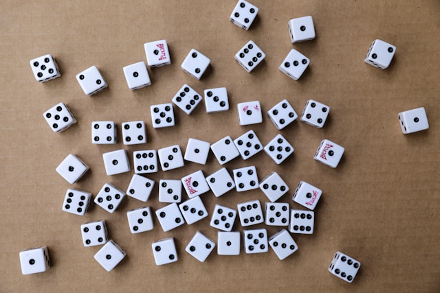 Multiple white dice with black dots that display different numbers.
