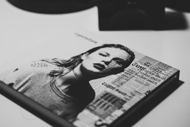 A portrait of Taylor Swift in black and white on the cover of a CD case.
