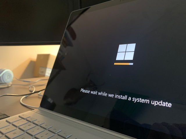 Un laptop gri cu ecranul de instalare a actualizării Windows.