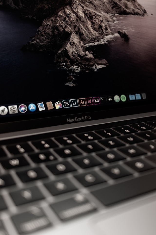 Een close-up van het dock van macOS met meerdere programma-pictogrammen op een grijze MacBook Pro.
