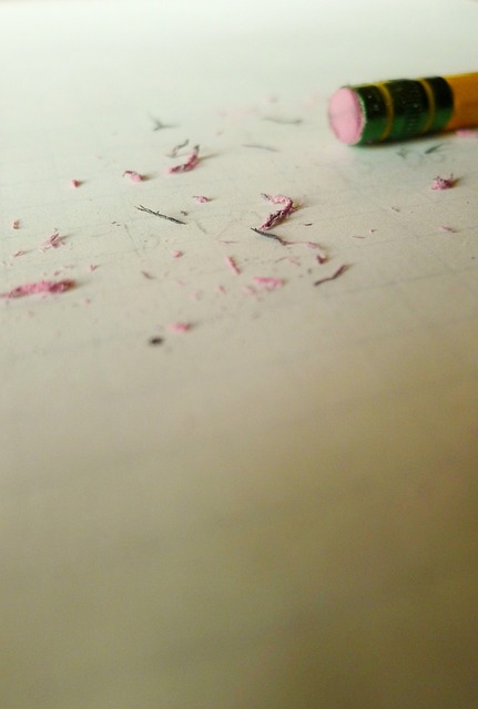Las migas de un borrador rosa sobre un papel de cuadros tenues.

