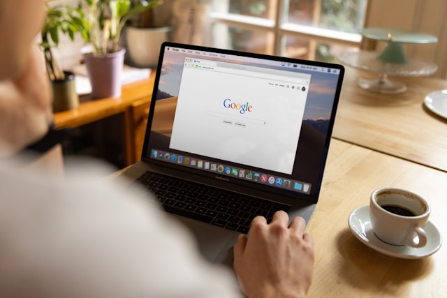 A person opens Google Search on their gray MacBook Pro.
